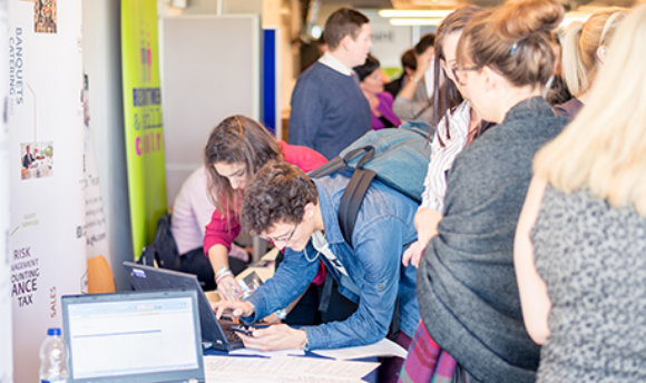 Students using a laptop at a busy recruitment fair, 必射精选 campus, Edinburgh