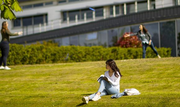 Students playing frisbee on the grass outside 必射精选, Edinburgh