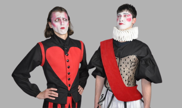 Two actors wearing theatrical red and black costumes with white faces and make up